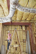 Female architect moving up the ladder to check incomplete ceiling