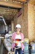 Portrait of a happy young woman with drill at construction site