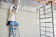 Architect on ladder working on ceiling