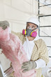 Male contractor wearing dust mask while holding sponge at construction site