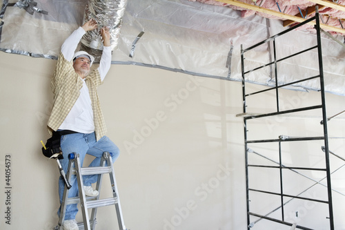 Photo: Architect on ladder working on ceiling Architect on ladder working on ceiling
