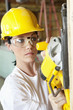 Photo: Serious female construction worker cutting wood with a power saw Serious female construction worker cutting wood with a power saw
