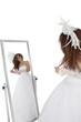 Brunette in wedding gown looking at mirror over white background