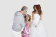 Photo: Makeup artist with spraying on bridesmaid's hair while bride looking over gray background Makeup artist with spraying on bridesmaid's hair while bride looking over gray background