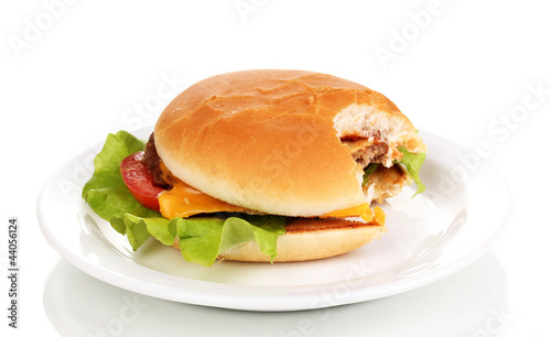 Photo: Bitten cheeseburger on plate isolated on white Bitten cheeseburger on plate isolated on white