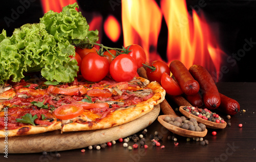 Foto: delicious pizza, salami, tomatoes and spices delicious pizza, salami, tomatoes and spices