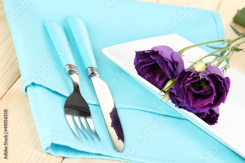 Foto: Tableware with flower on bright napkin close-up Tableware with flower on bright napkin close-up