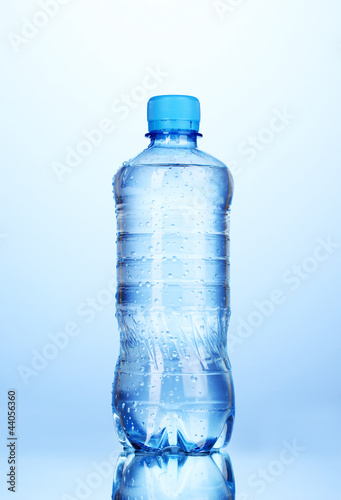 Photo: plastic bottle of water on blue background plastic bottle of water on blue background