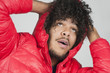 Close-up of young man with curly hair looking up over colored background