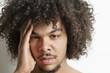 Portrait of young man having headache over white background