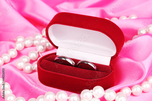 Foto: Wedding rings in red box on pink cloth background Wedding rings in red box on pink cloth background