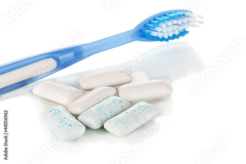 Photo: Chewing gum and toothbrush close-up isolated on white Chewing gum and toothbrush close-up isolated on white