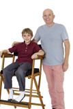 Photo: Portrait of senior man with pre-teen boy sitting on director's chair over white background Portrait of senior man with pre-teen boy sitting on director's chair over white background