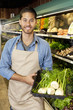 Photo: Portrait of a happy man with basket full of green onion in supermarket Portrait of a happy man with basket full of green onion in supermarket