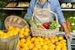 Photo: Midsection of man standing near oranges stall with vegetable basket in supermarket Midsection of man standing near oranges stall with vegetable basket in supermarket