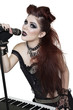 Photo: Portrait of beautiful punk woman playing piano while singing with microphone over white background Portrait of beautiful punk woman playing piano while singing with microphone over white background