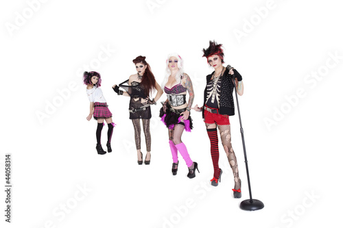 Photo: Portrait of beautiful all female band with microphone over white background Portrait of beautiful all female band with microphone over white background