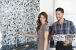Foto: Portrait of beautiful young couple with color samples standing in model home kitchen Portrait of beautiful young couple with color samples standing in model home kitchen