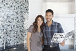 Beautiful happy couple with color samples in modern kitchen