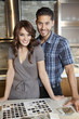 Foto: Portrait of beautiful young couple standing in model home kitchen with tile color samples Portrait of beautiful young couple standing in model home kitchen with tile color samples