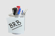 Close-up of sticky note with message on pen holder over white background