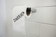 Close-up of toilet paper roll with diarrhea written in bathroom