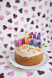 Foto: Close-up of birthday cake with candles over heart shaped background Close-up of birthday cake with candles over heart shaped background