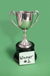 Trophy with sticky note for winner over colored background
