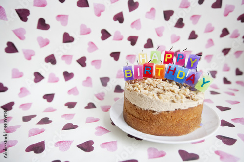 Photo: Close-up of birthday candles on cake over heart shaped background Close-up of birthday candles on cake over heart shaped background