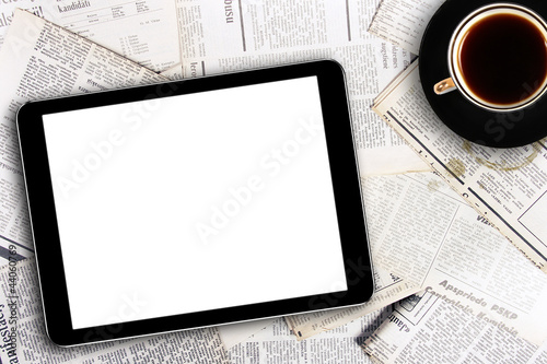 Photo: digital tablet and coffee cup on newspapers digital tablet and coffee cup on newspapers
