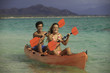 couple paddling their kayak in hawaii