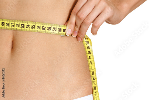 Photo: Woman measuring her waist Woman measuring her waist