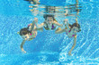 Happy family underwater in swimming pool, fun on summer vacation