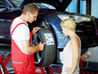 Foto: Mechanic in a garage explaining tyre labeling to a customer Mechanic in a garage explaining tyre labeling to a customer