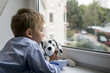 little boy with a toy near a window