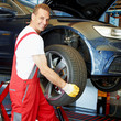 Motor mechanic is changing a summer tyre in a garage