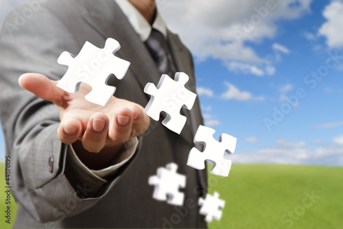 Photo: businessman hand and business puzzles as concept businessman hand and business puzzles as concept