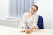 Genervte Frau mit Handy und Notizzettel im Büro