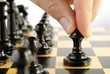 man playing chess, and shows the hand of chess pieces