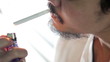 a man lighting a cigarette and smoke