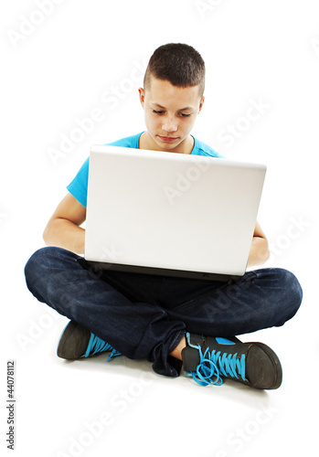 Photo: Handsome teenager boy using laptop Handsome teenager boy using laptop