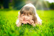 Little smiling girl lying on grass