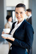 beautiful young businesswoman drinking coffee in office
