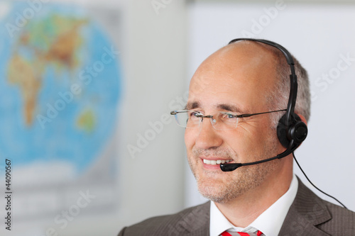 Foto: geschäftsmann mit headset vor einer landkarte geschäftsmann mit headset vor einer landkarte