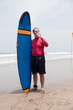 man the surfer to stand on a beach and drinks water