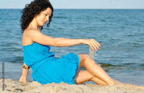 Photo: Woman playing with sea sand Woman playing with sea sand