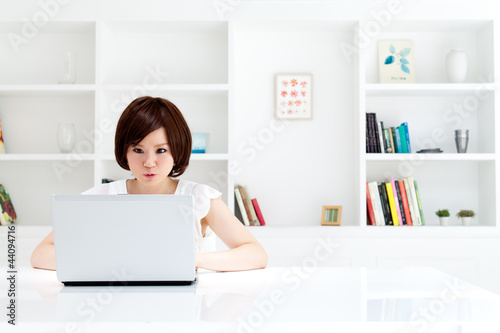 Foto: Beautiful young business woman using a laptop computer. Portrait Beautiful young business woman using a laptop computer. Portrait