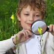 boy with magnifying glass outdoors