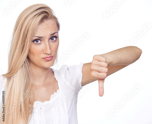 Photo: Woman with thumbs down - isolated over a white background Woman with thumbs down - isolated over a white background