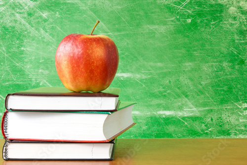 Photo: books with apple against dirty chalkboard books with apple against dirty chalkboard